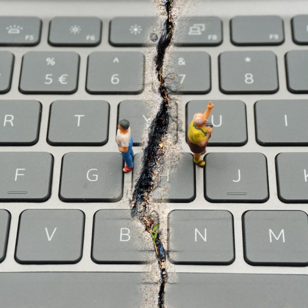 Internet Confrontation.digital divide.The keyboard is split by the cracks that separate the opposites.Social Divide.Divided world.conflicts.cyberbullying.